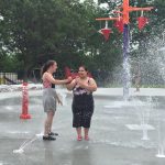 Teen girls playing outside at a fountain park