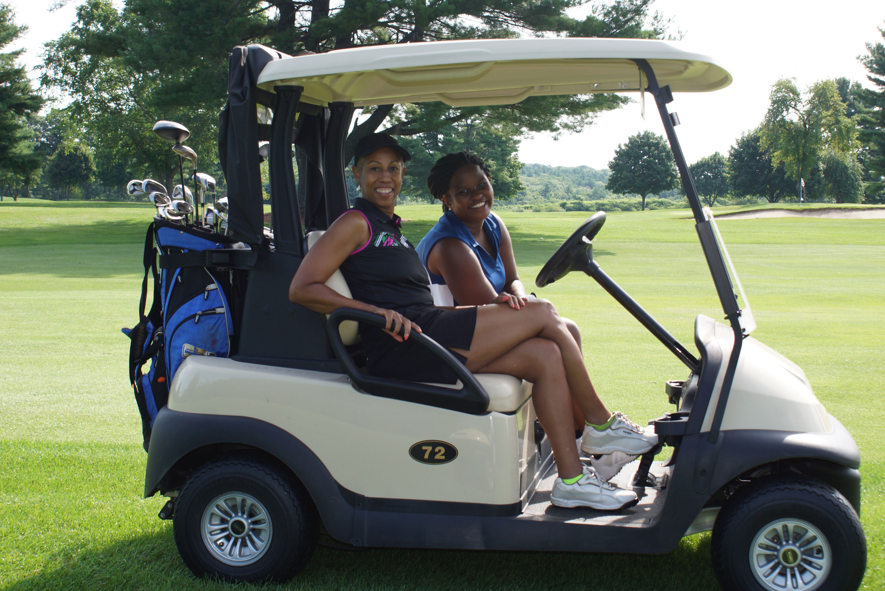 A Golf Van with Two Women Sitting Highlighting Annual YMCA Golf Events in  Central Massachusetts.