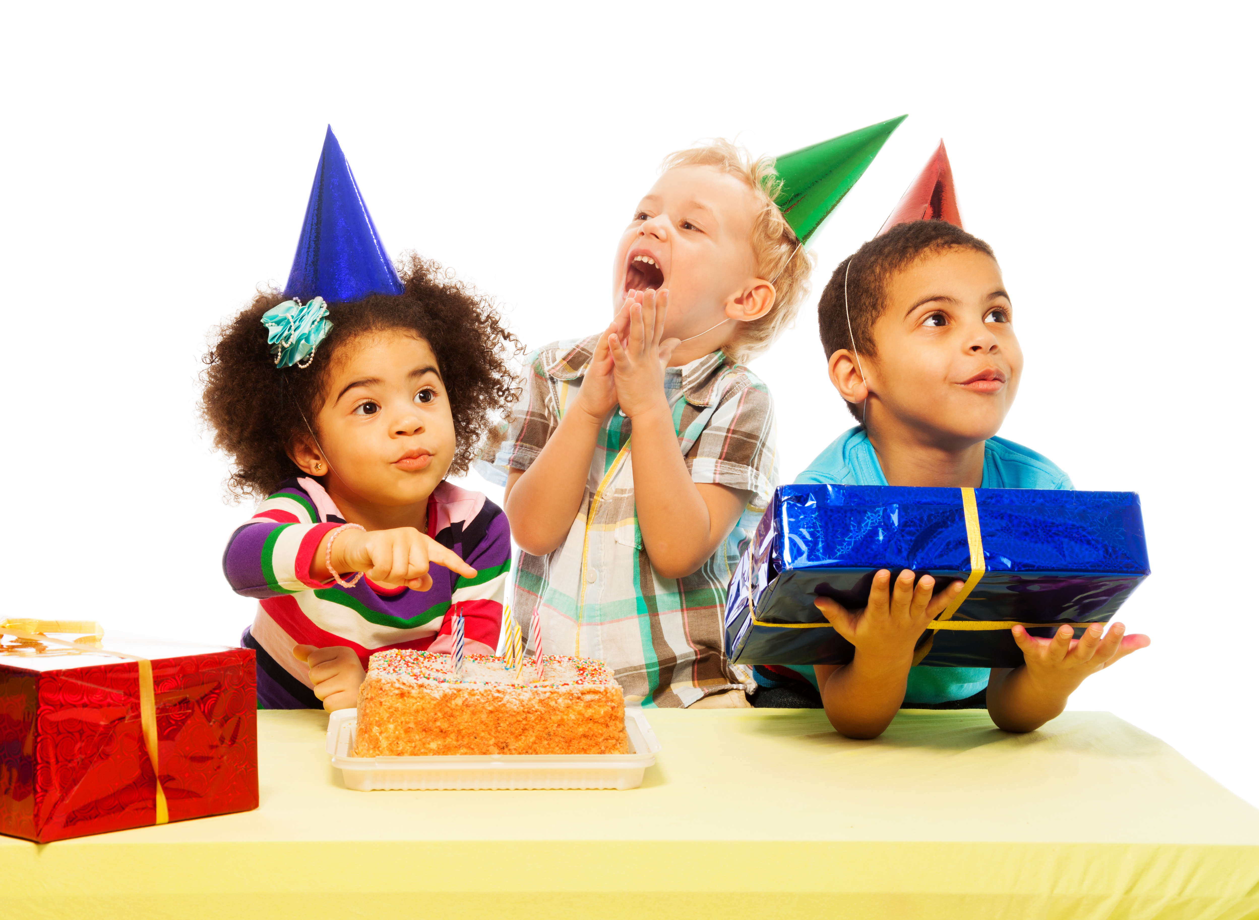 Three kids with different appearance sitting by the table with presents and birthday cake