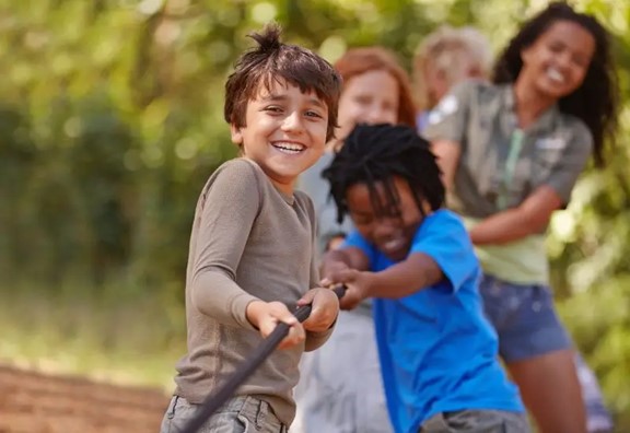 Children playing tug a war at summer camp