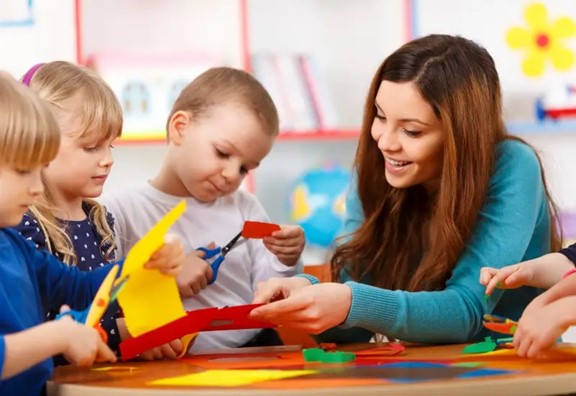 Group of preschool children learning to use scissors