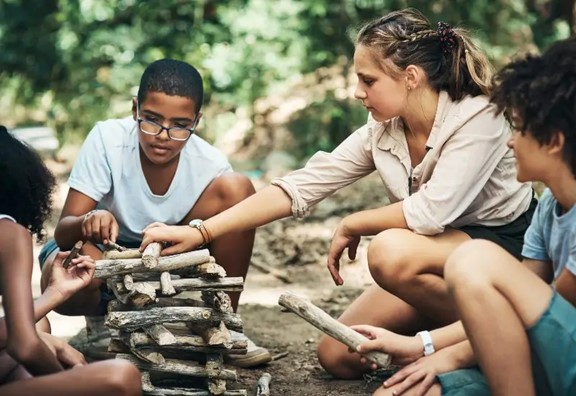 Group of teenagers playing with firewood in Central Massachusetts