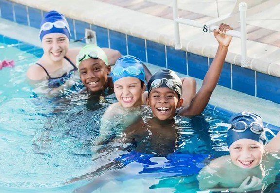 Kids in pool wearing swim caps