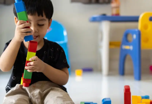 Toddler building towers with legos