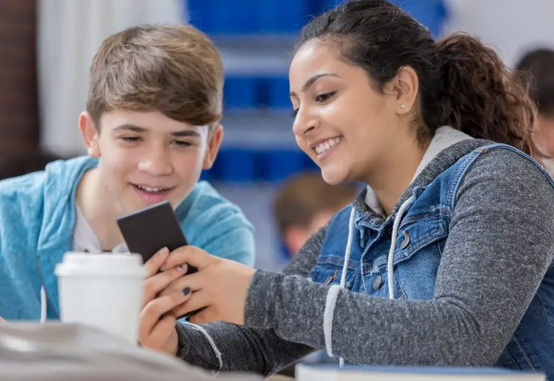 Boy with mom looking at a phone together 