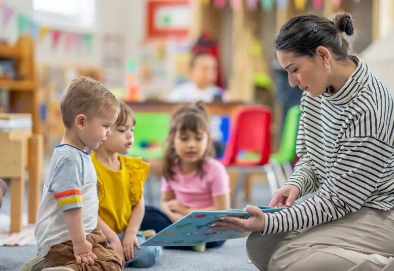 Woman reading to young toddlers