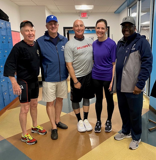 A group of people posing for a picture near the locker room area