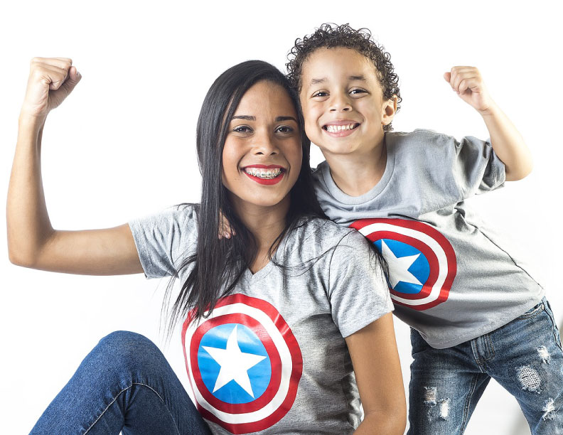 A mother and son posing for a picture wearing the same t-shirt