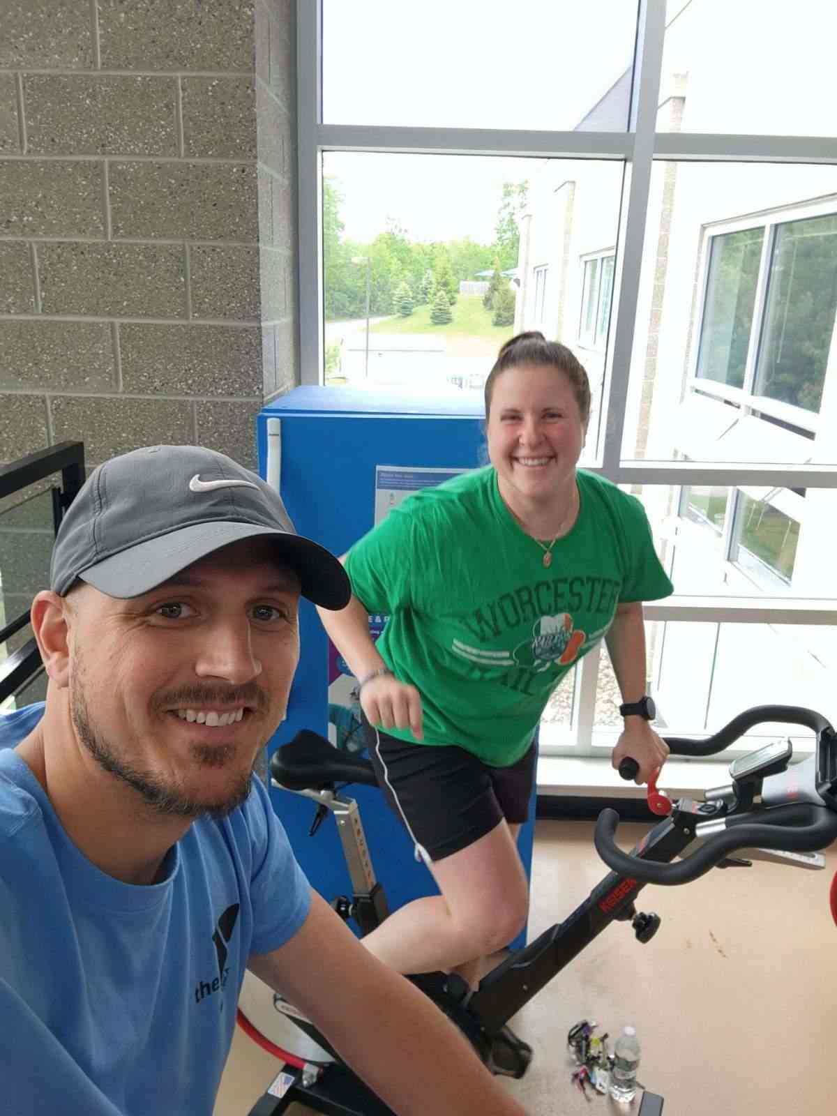 A young couple doing indoor cycling at a gym in Central Massachusetts