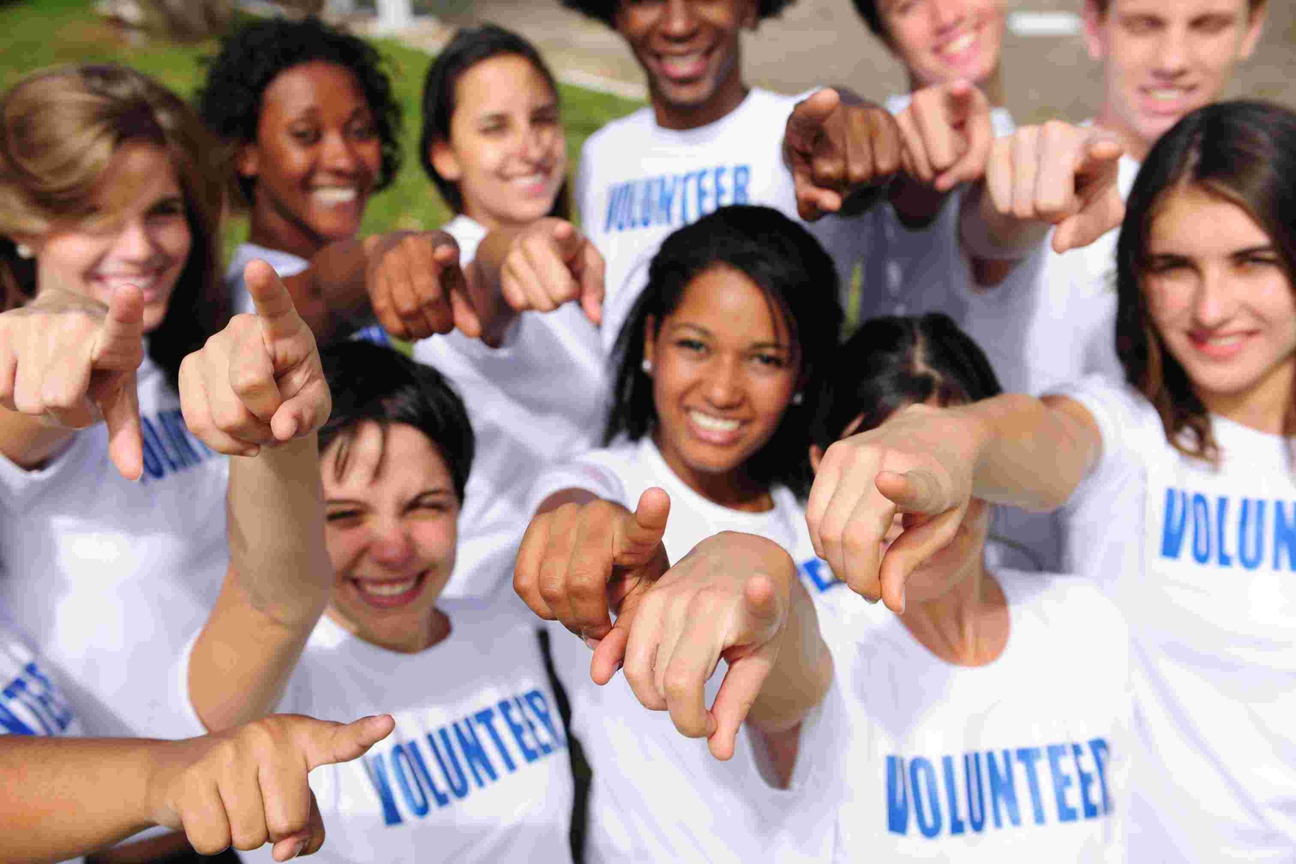 A group of volunteers pointing at the camera