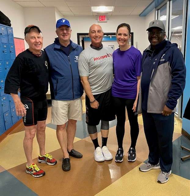 A group of people posing in a locker room of a basketball court in Central Massachusetts